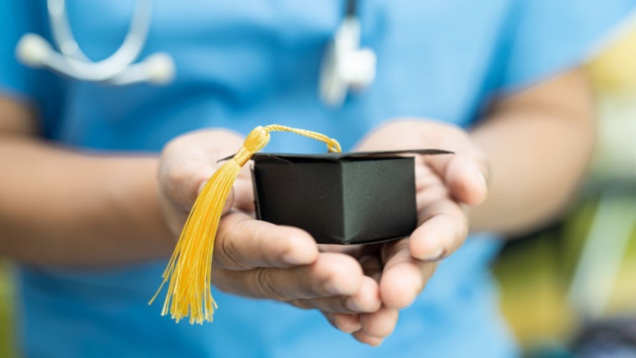 Asian doctor study learn with graduation gap hat in hospital ward, clever bright genius education medicine concept.